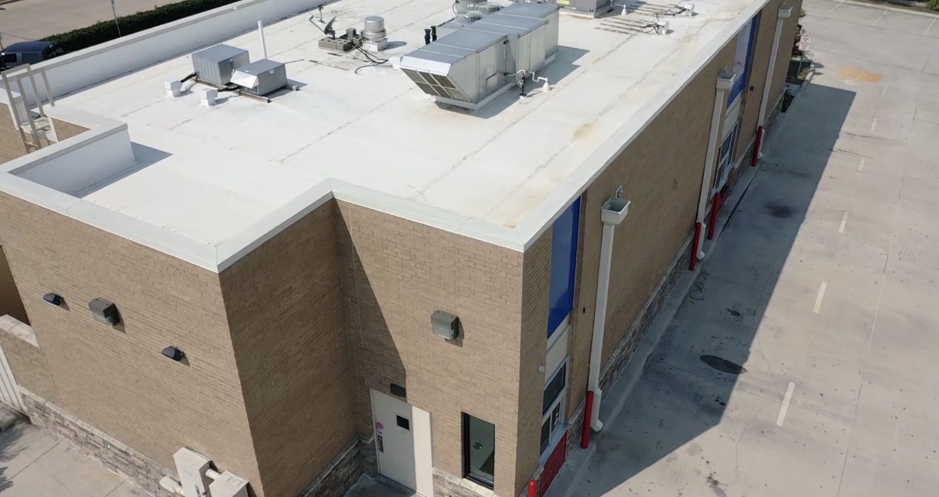 Vista con dron del techo de un edificio comercial con unidades en el techo y pretiles