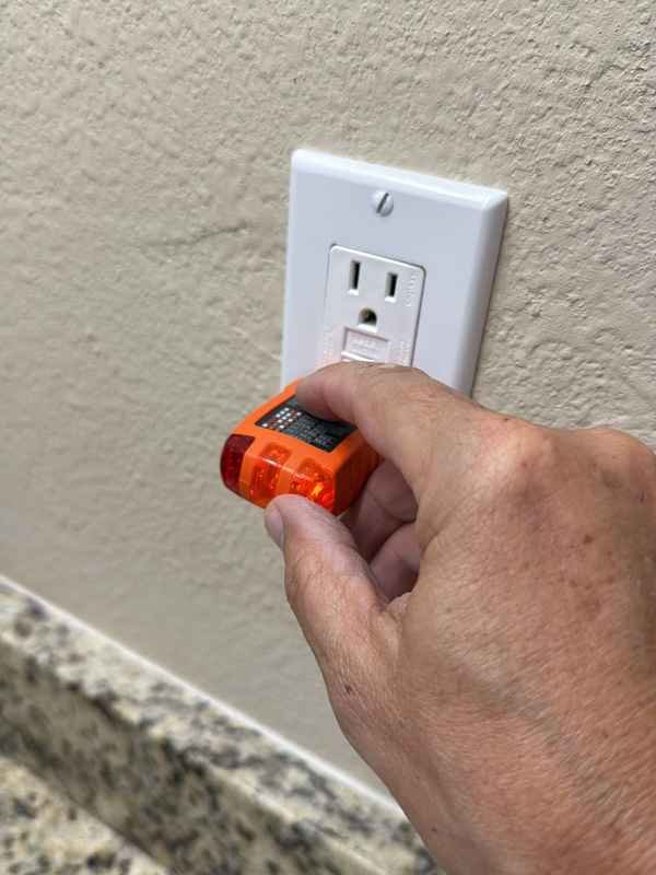 Inspector testing a GFCI receptacle with an outlet tester