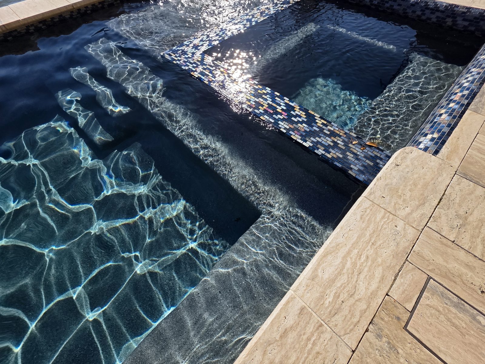 Escalones de azulejo de la alberca y pared del jacuzzi con agua clara
