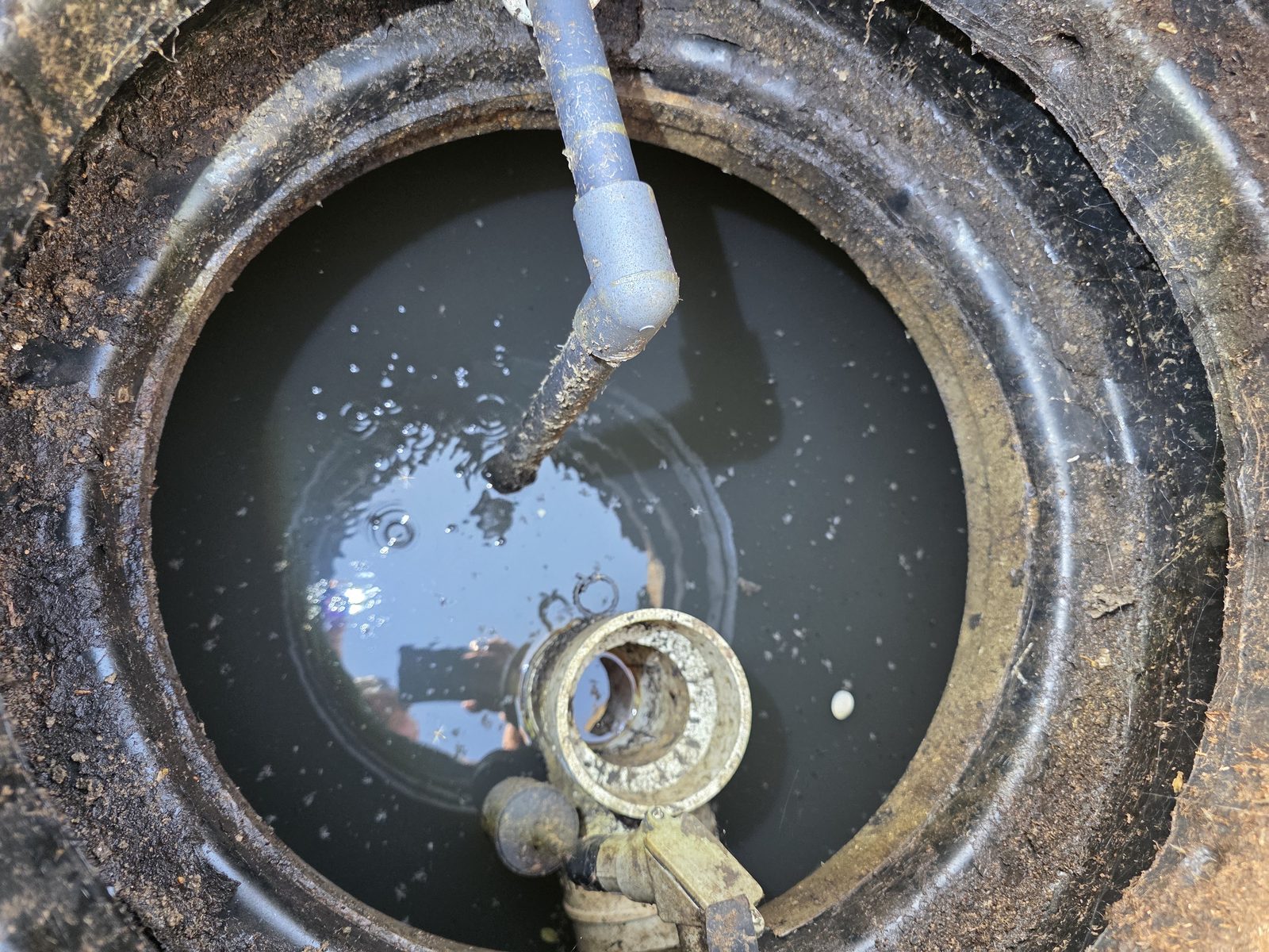 Abertura del tanque séptico con filtro de salida y nivel de líquido visibles