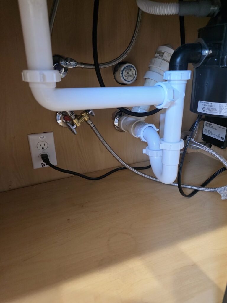 Drenaje y trampa del lavabo debajo del gabinete