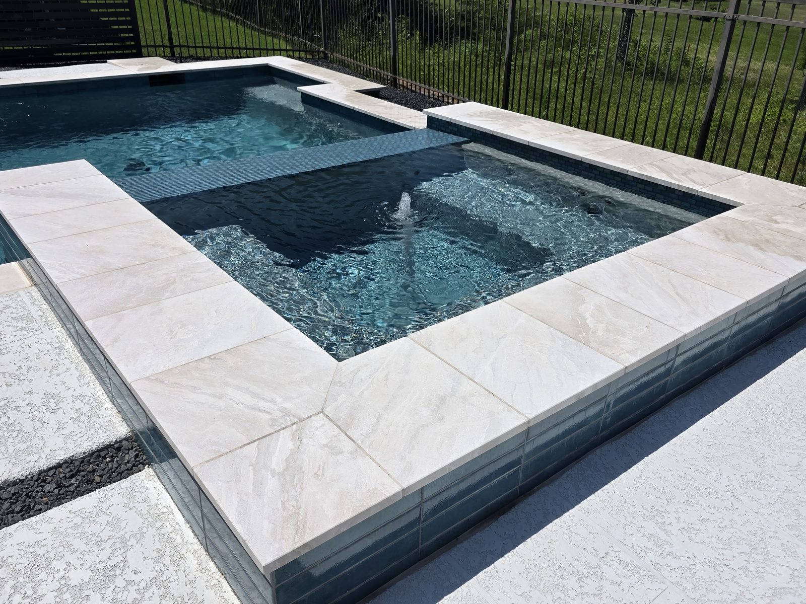 Jacuzzi elevado con borde de cascada hacia la alberca