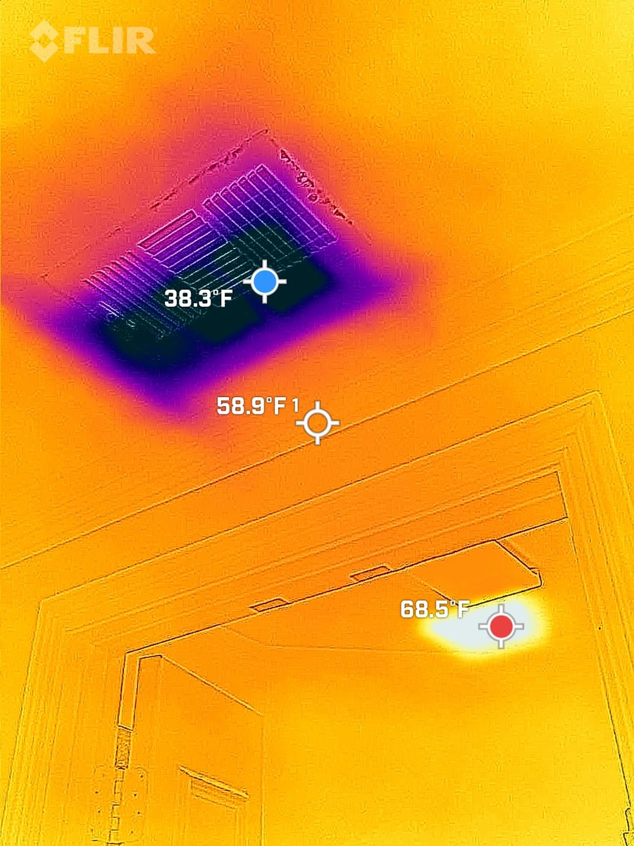 FLIR thermal image of a ceiling supply register blowing cold air, reading 38.3°F against a 58.9°F ceiling